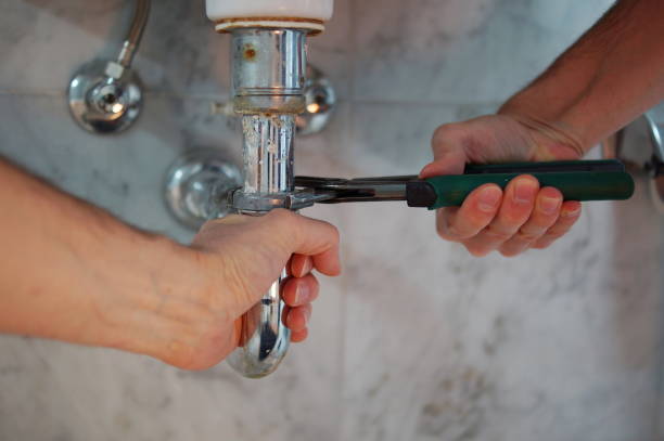 Plumber repairs sink at work